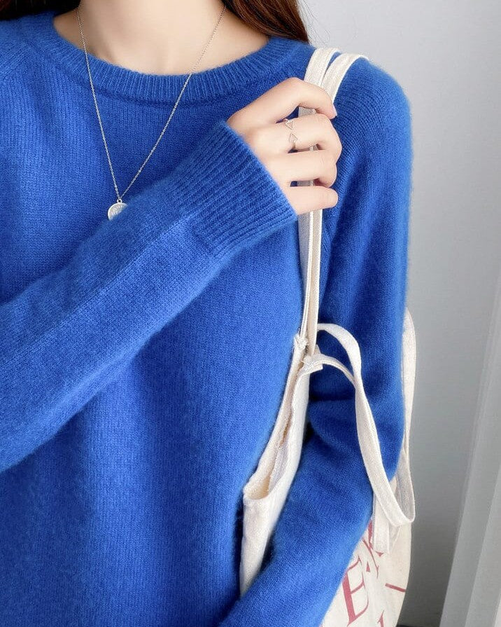 pull bleu pur laine pour femme modèle elsa porté avec un collier délicat et un sac en coton écru