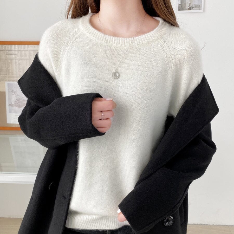 pull pur laine femme elsa avec un manteau noir élégant devant une fenêtre dans une pièce lumineuse et minimaliste