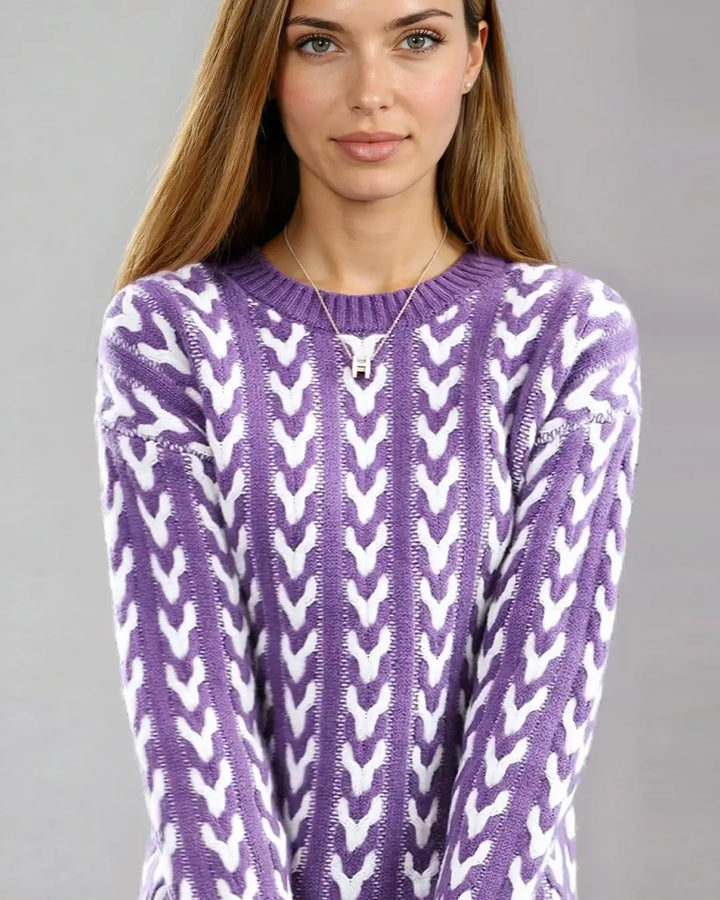 Femme portant un pull torsadé bicolore amaryllis avec motif unique, idéal pour une tenue chic et tendance en hiver.