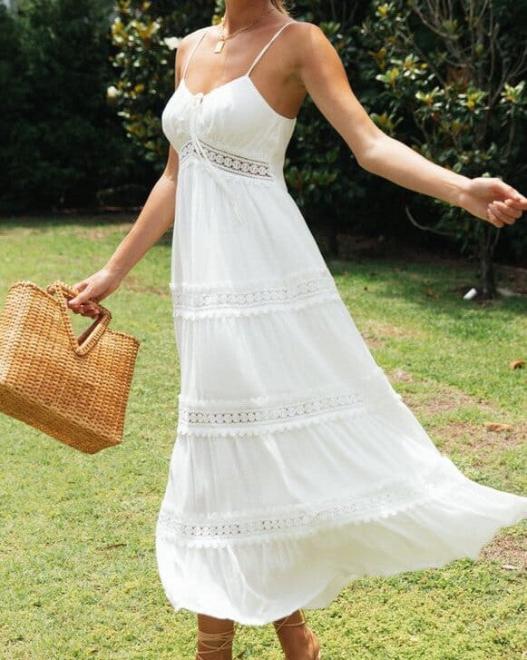 femme portant une robe blanche boheme avec un panier en osier dans un jardin ensoleillé