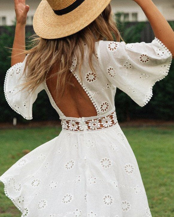 robe bohème dos nu en dentelle blanche courte avec manches évasées et chapeau de paille, modèle en plein air