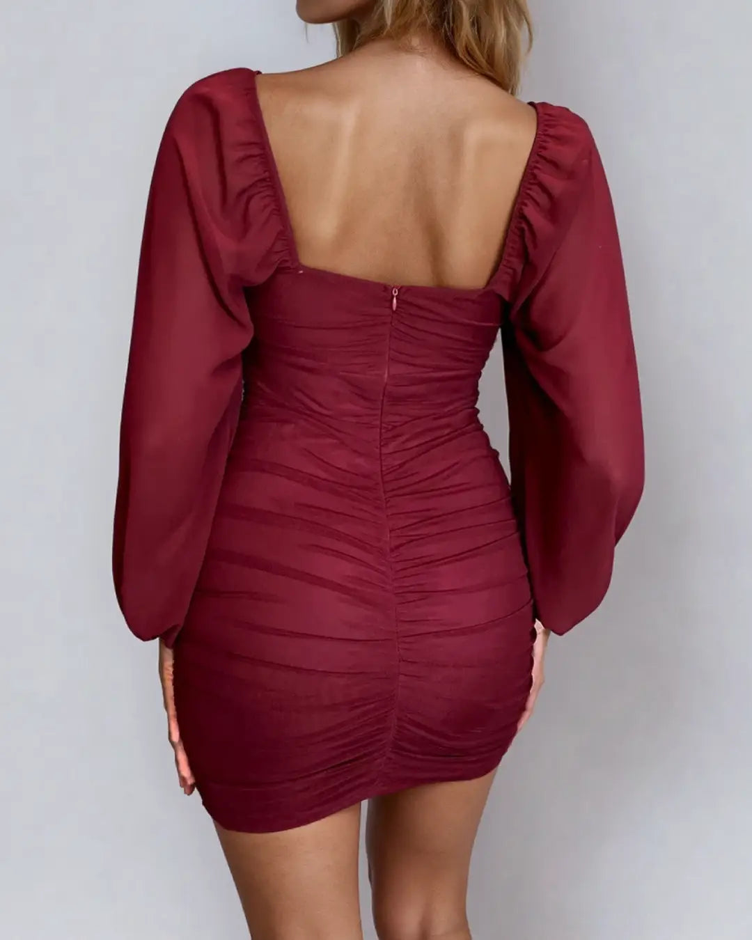 Robe dos nu à manches longues de couleur bordeaux, idéale pour une soirée élégante, mettant en valeur le dos et les plis.