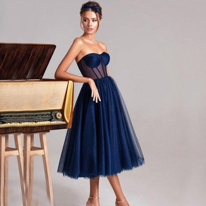 femme en robe longue tulle bleu marine ludivine élégante, tête de lit vintage en arrière-plan, buste ajusté