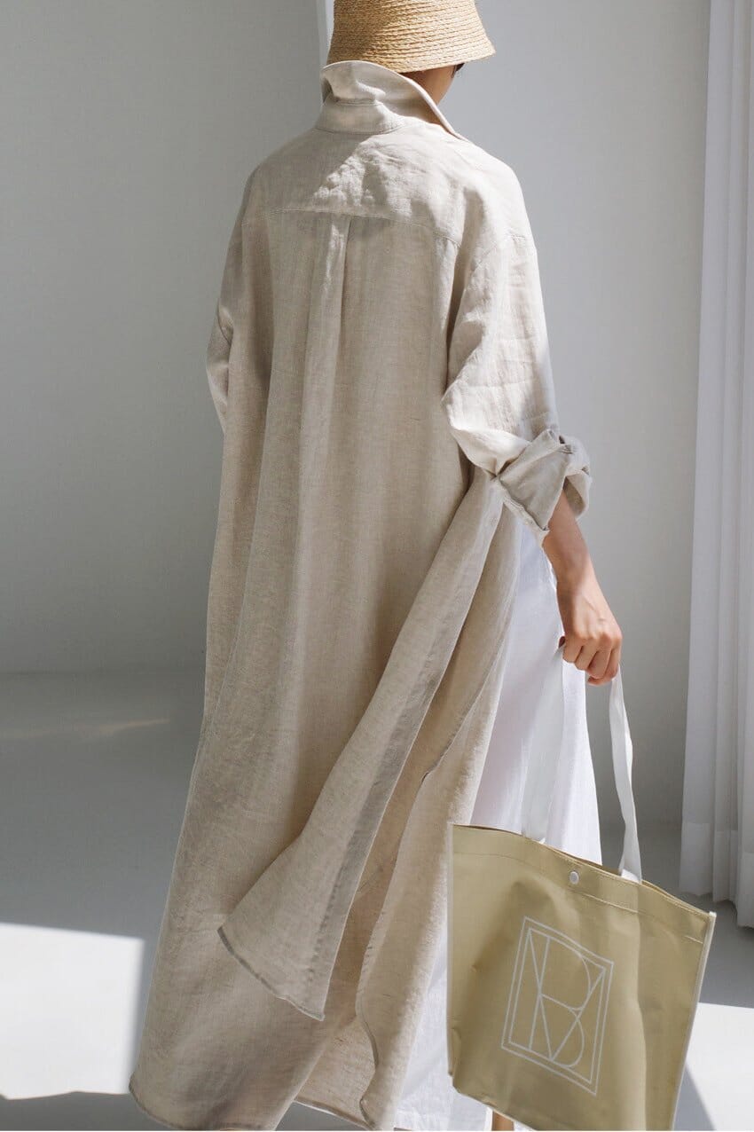 robe chemise en lin esther beige portée avec un chapeau en paille et un sac en toile beige à la main, vue arrière