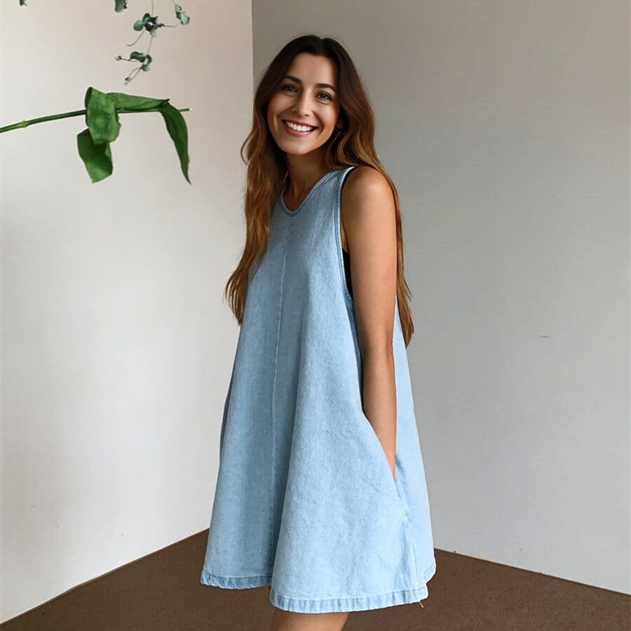 jeune femme portant une robe en jean courte jordana dans un intérieur minimaliste avec un sourire éclatant