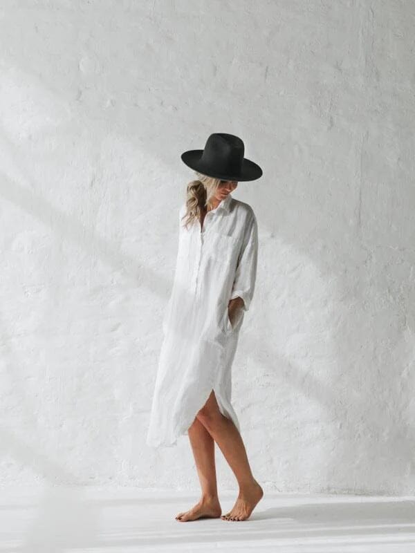 longue robe chemise blanche élégante avec chapeau noir, parfaite pour un style casual ou une tenue décontractée