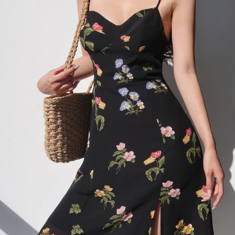 robe longue fleurie maria avec fente et motifs floraux colorés, portée avec un sac en osier pour un look estival élégant