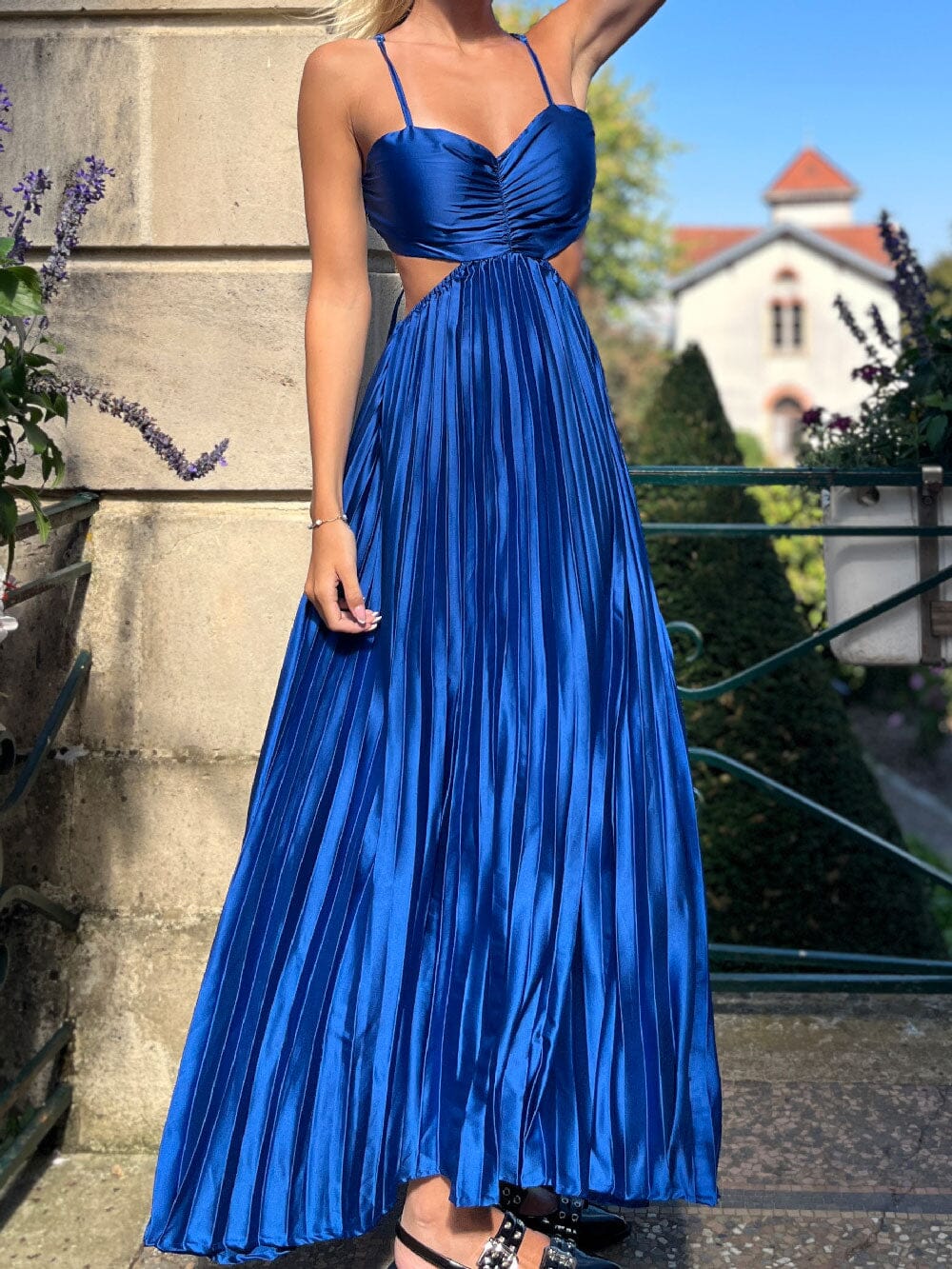 Robe de soirée longue élégante de couleur bleue avec dos nu et jupe plissée, parfaite pour un événement formel.