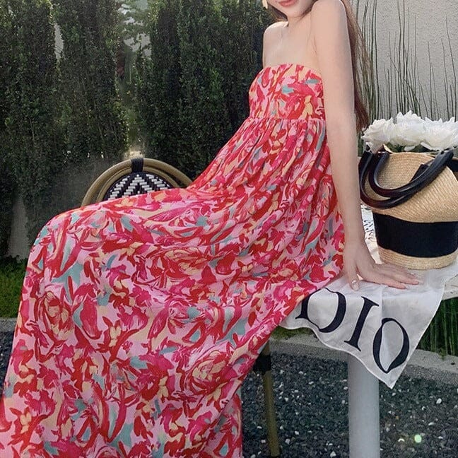 robe longue bustier colorée à imprimé floral portée par une femme assise dans un jardin avec un sac en osier