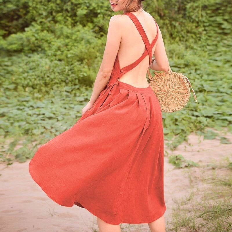 robe lin dos nu modèle louisa croisé à bretelles larges avec jupe évasée en arrière-plan naturel avec sac rotin