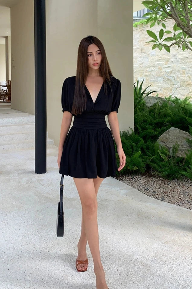 jeune femme portant une robe chemise courte noire pour l'été dans un cadre extérieur moderne, chic et élégant