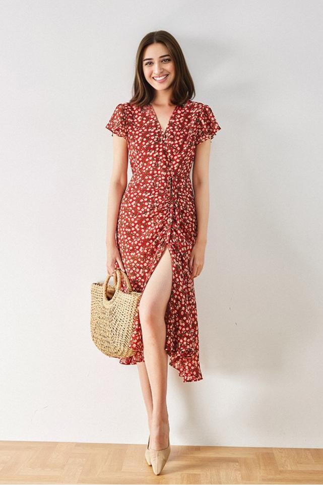 robe longue rouge avec motif floral portée par une femme souriante tenant un sac en osier