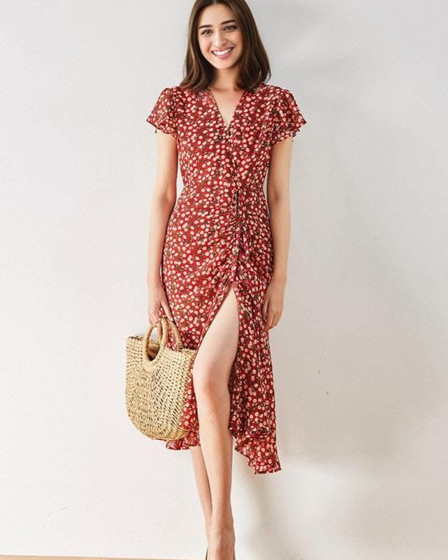 robe longue rouge avec motif floral portée par une femme souriante tenant un sac en osier