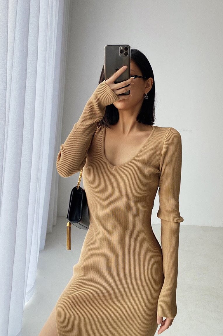 Femme portant une robe pull longue beige Céline, style élégant et moderne idéal pour l'hiver et les occasions décontractées.