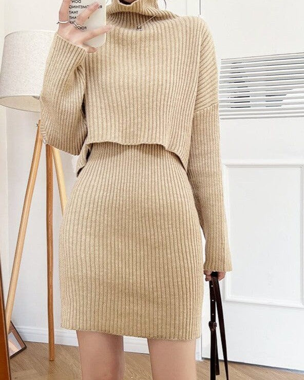 Robe pull en maille beige deux pièces pour femme avec col roulé, manches longues et jupe courte dans un intérieur moderne.