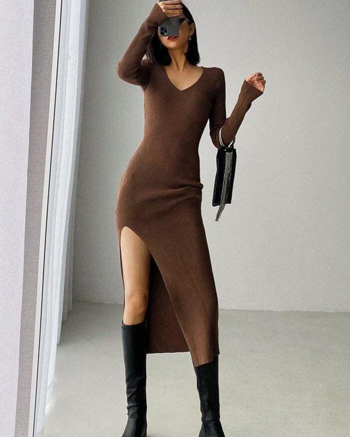 Femme portant une élégante robe pull longue marron avec fente, style moderne, parfaite pour l'automne et l'hiver.