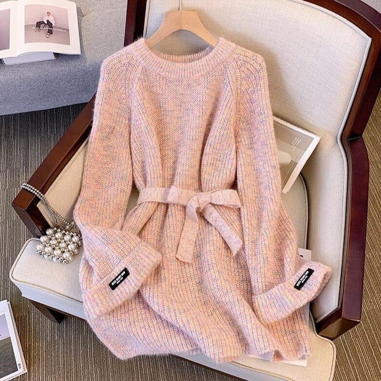 robe pull en laine rose avec ceinture, manches longues, posée sur un fauteuil beige, intérieur cosy et élégant