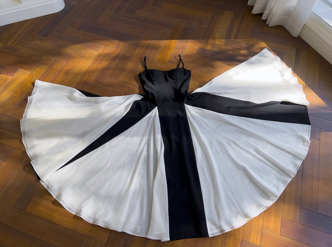 robe de bal noire léonora édition limitée avec jupe évasée en motif noir et blanc étalée sur un parquet en bois