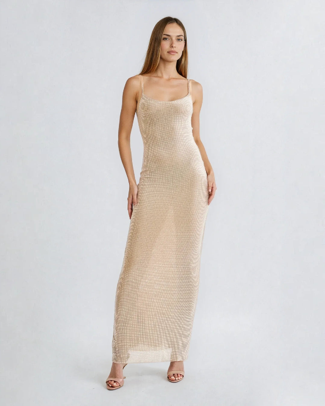 Robe cocktail strass Nessa, élégance sophistiquée, soirée glamour, femme assise sur canapé en ambiance tamisée.