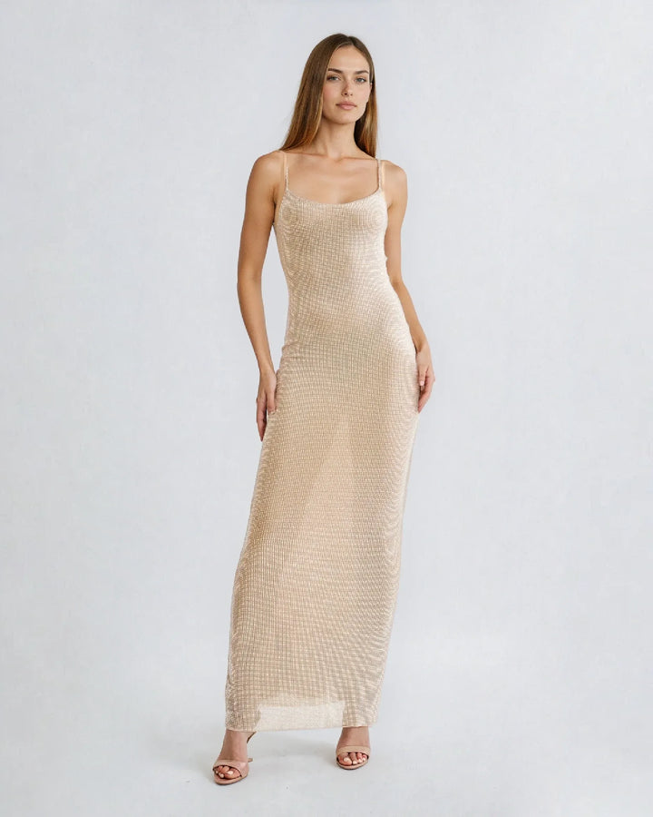 Robe cocktail strass Nessa, élégance sophistiquée, soirée glamour, femme assise sur canapé en ambiance tamisée.