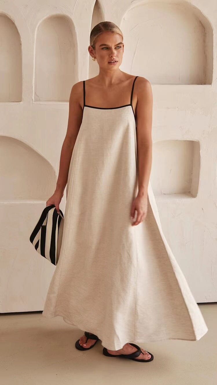 robe trapèze longue bella blanche avec fines bretelles, sac à rayures noir et blanc, dans intérieur minimaliste