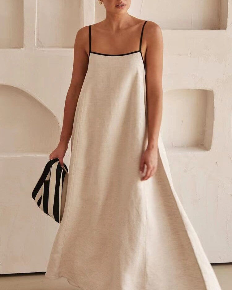 robe trapèze longue bella blanche avec fines bretelles, sac à rayures noir et blanc, dans intérieur minimaliste