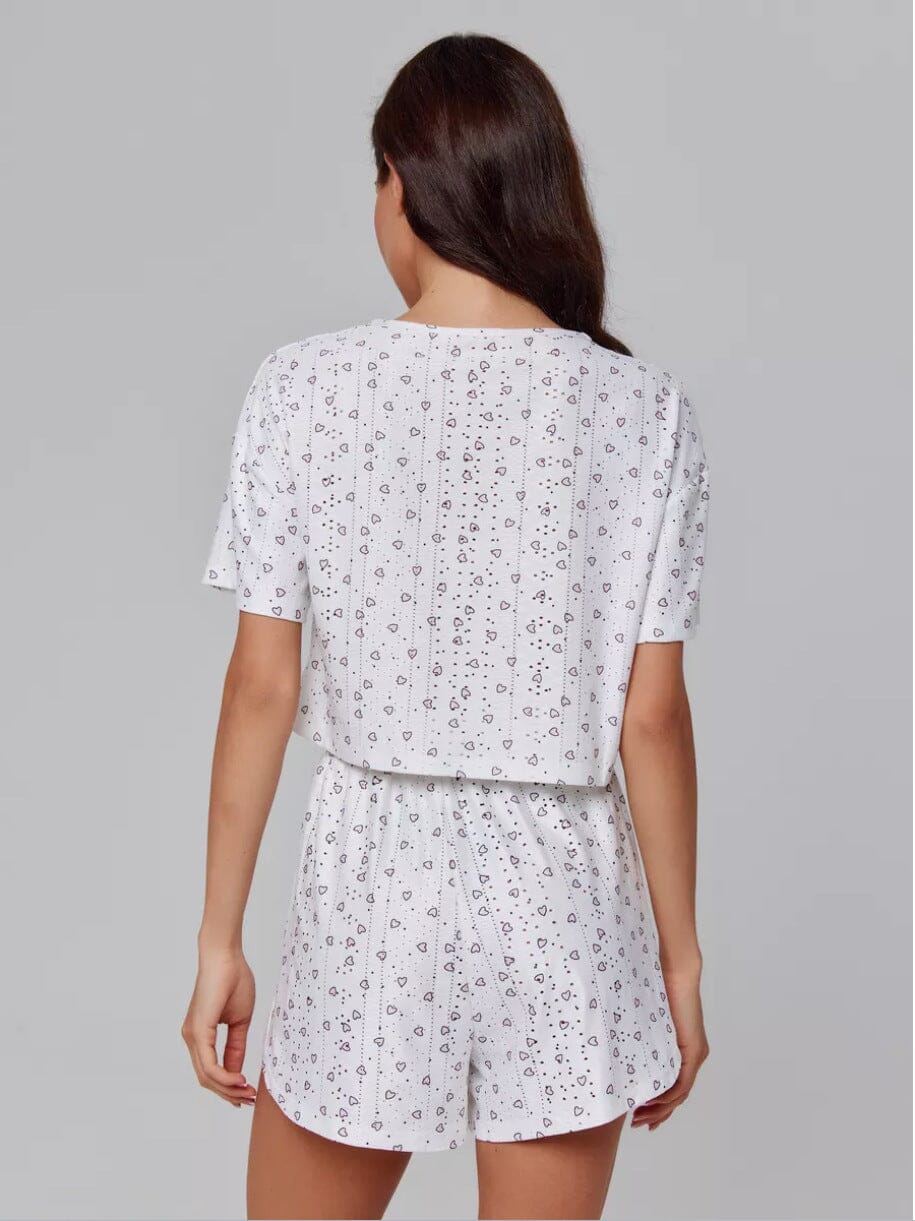 femme de dos portant un pyjama short blanc avec motifs délicats, modèle eugénie, confortable et estival