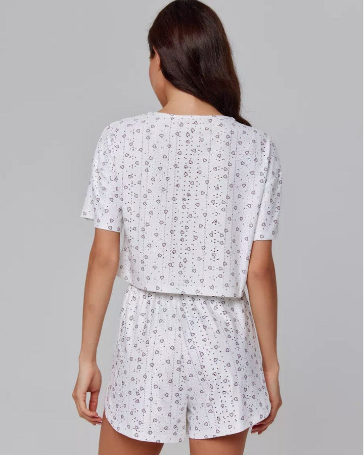 femme de dos portant un pyjama short blanc avec motifs délicats, modèle eugénie, confortable et estival