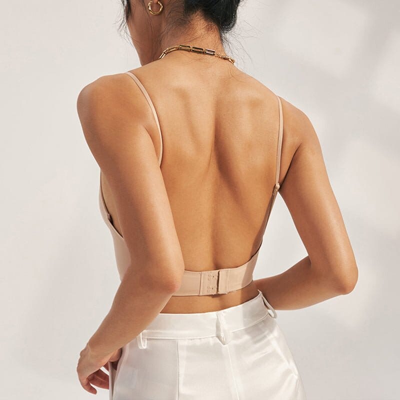 femme portant un soutien-gorge dos nu invisible Alexia couleur chair avec un pantalon blanc, vue de dos montrant la fermeture