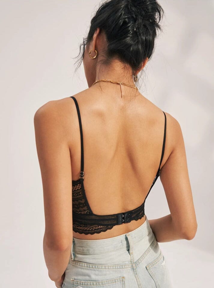 Femme portant un soutien-gorge dos nu invisible en dentelle noire, vue de dos, idéal pour des tenues ouvertes.