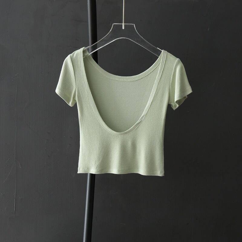 tee shirt dos nu lilia en coton vert clair élégant et tendance suspendu sur cintre contre fond sombre