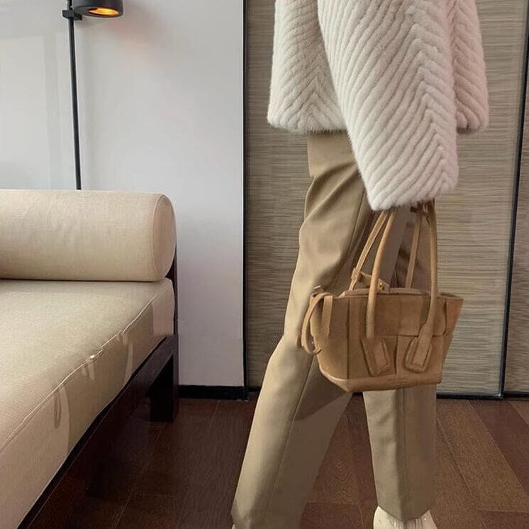 veste femme fausse fourrure chic marcella beige avec détails élégants, combinée avec un sac à main tendance et un décor moderne