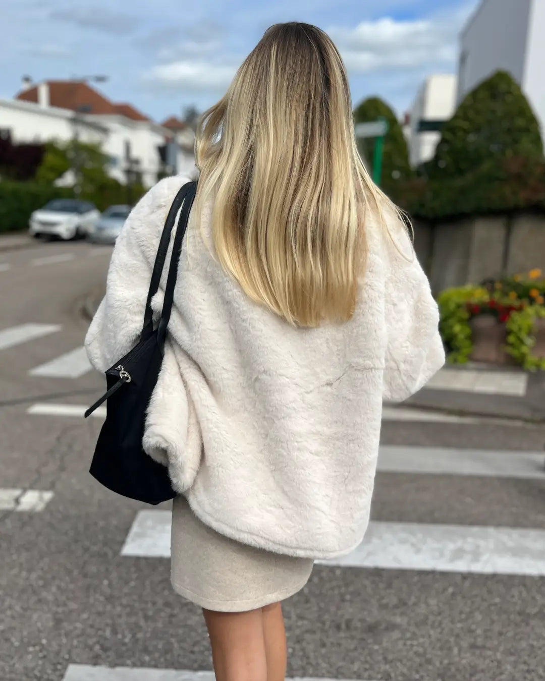 Femme portant la veste en fausse fourrure "Julia", élégance et confort pour une tenue d'automne en ville.