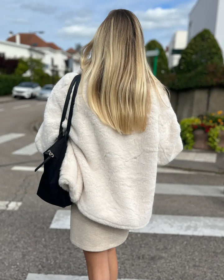 Femme portant la veste en fausse fourrure "Julia", élégance et confort pour une tenue d'automne en ville.