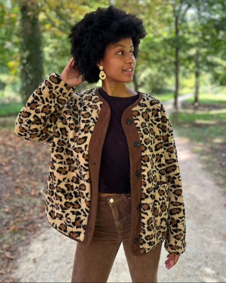 Femme portant une veste en polaire à motif léopard dans un parc, style automnal décontracté et élégant