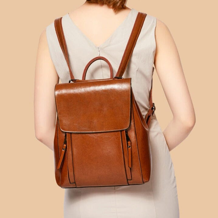 sac à dos en cuir marron pour femme, élégant et pratique, porté par une femme en robe beige, parfait pour toutes occasions