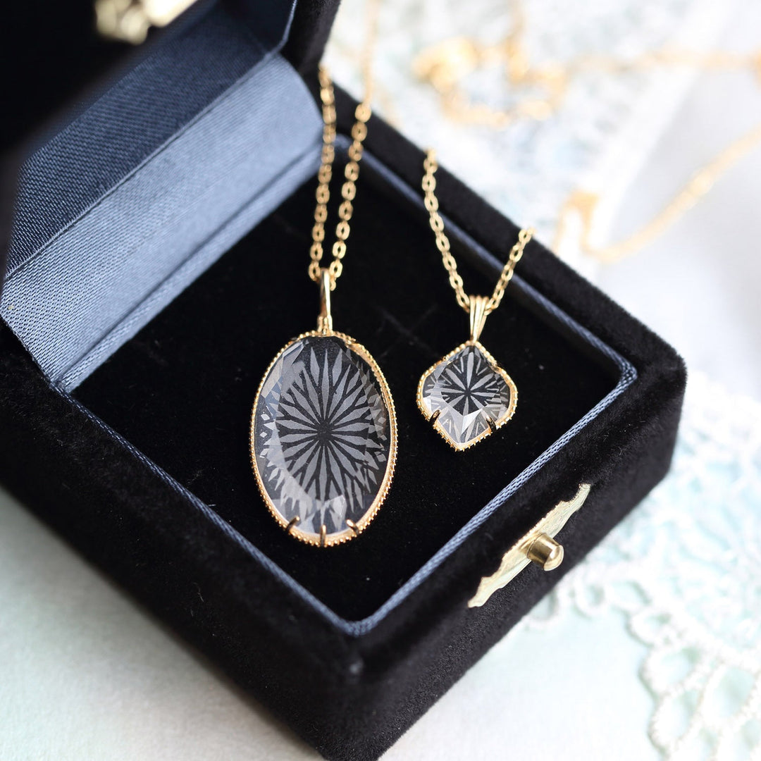 collier pendentif losange en cristal alina dans un écrin noir, bijou élégant en or avec design géométrique gravé