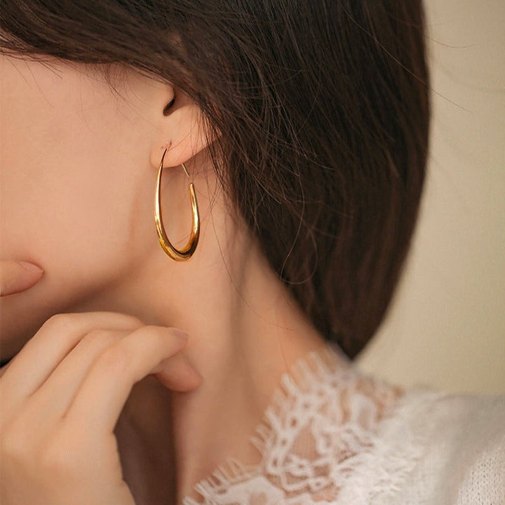 anneaux dorés créoles portées par une femme, bijou élégant pour oreilles, accessoire de mode tendance, boucle en or