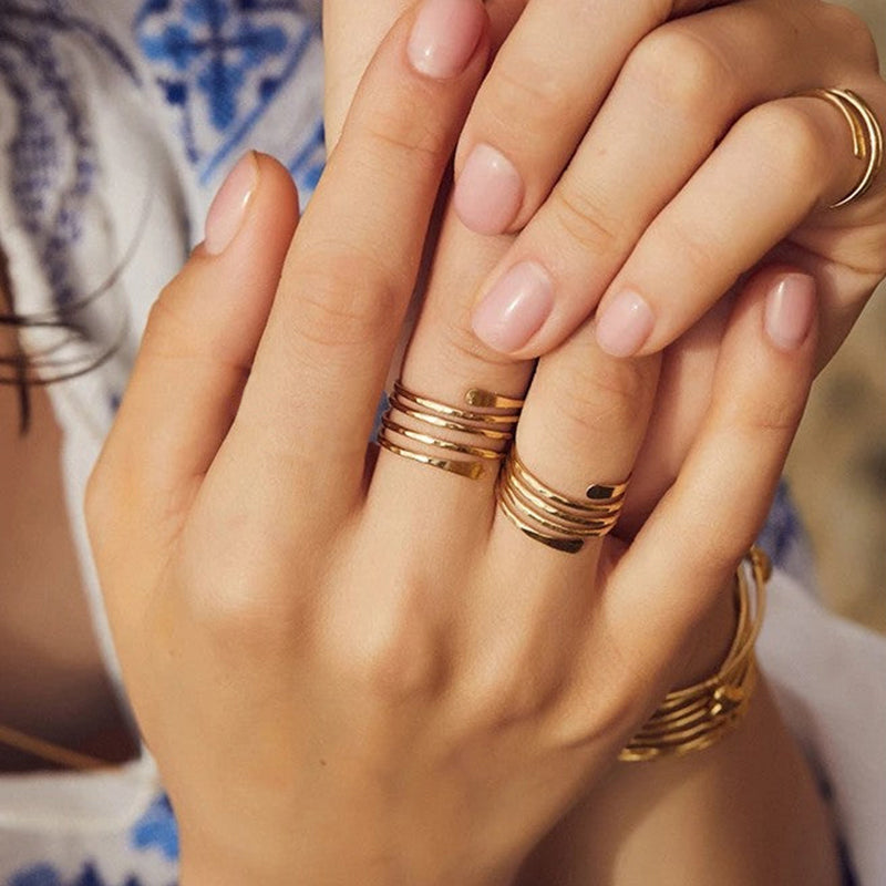 bague spirale en or vanna portée sur plusieurs doigts d'une main, accessoire élégante et moderne parfait pour toutes occasions