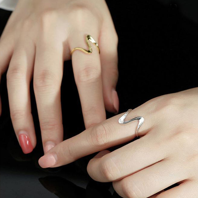 bague vague dorée argentée portée par des mains, design élégant et moderne, bijou tendance pour femmes, style contemporain
