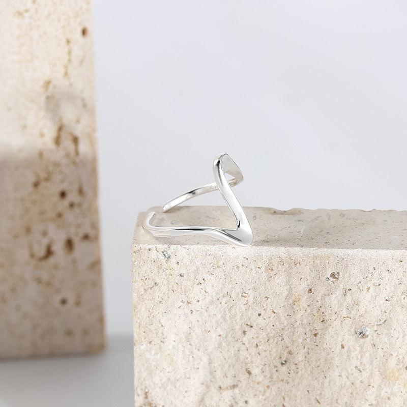 bague vague dorée et argentée sur fond de pierre, bijou élégant et moderne pour les amoureux de la mode minimaliste