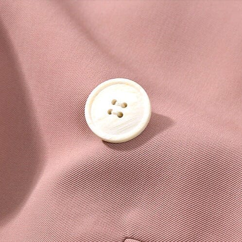 détail du bouton crème sur un tissu rose pour le blazer boyfriend de Léonie