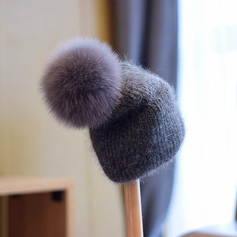 bonnet en laine gris pour femme avec un grand pompon rond, modèle lara, accessoire d'hiver élégant et confortable