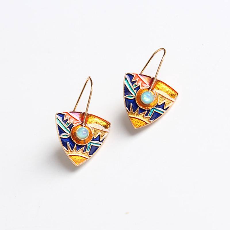 boucles d'oreilles pendantes colorées au style inca en or et pierres bleues avec motifs géométriques