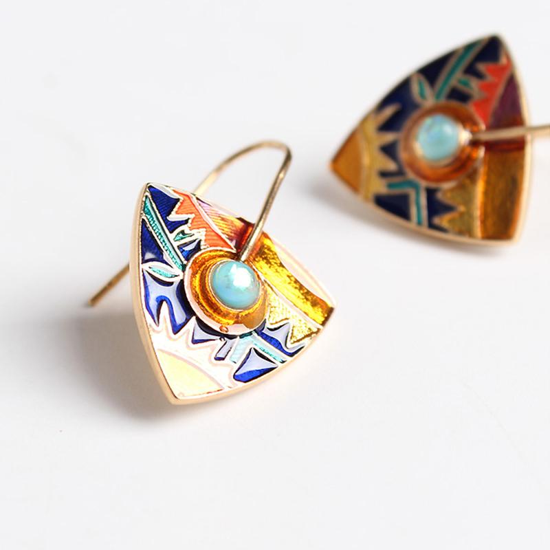 boucles d'oreilles pendantes inca en or colorées avec motifs géométriques et pierre turquoise au centre
