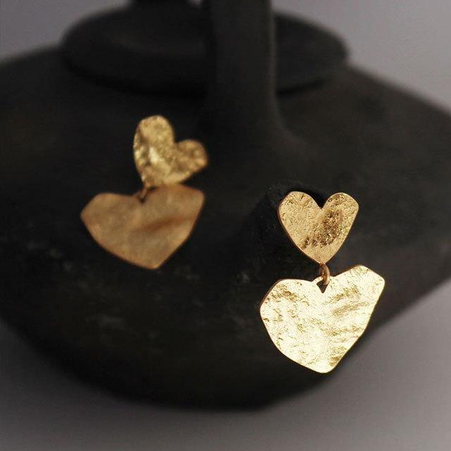 Boucles d'oreilles en forme de cœur en or, idéales pour ajouter une touche élégante et romantique à n'importe quelle tenue.