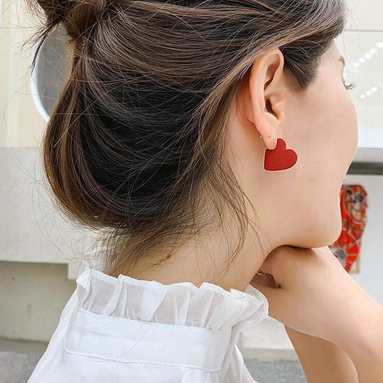 boucles d'oreilles en forme de cœur rouge portées par une jeune femme, accessoire mode romantique et tendance