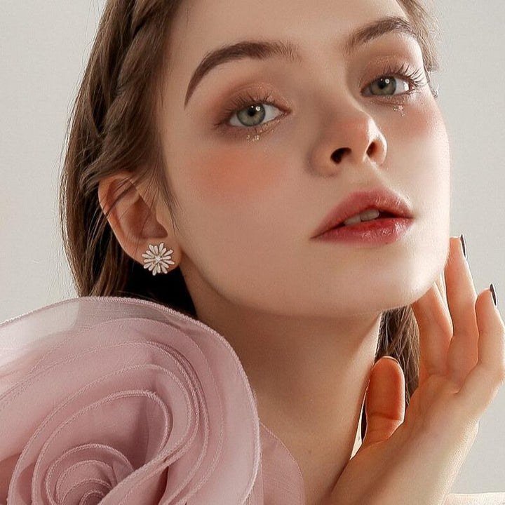 boucles d'oreilles marguerite en diamant portées par une jeune femme élégante, idéale pour occasions spéciales