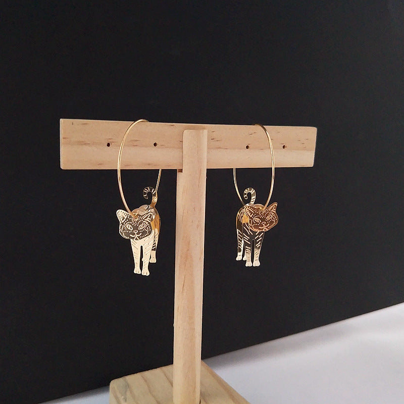 boucles d'oreilles chic en or avec pendentif chat sur support en bois