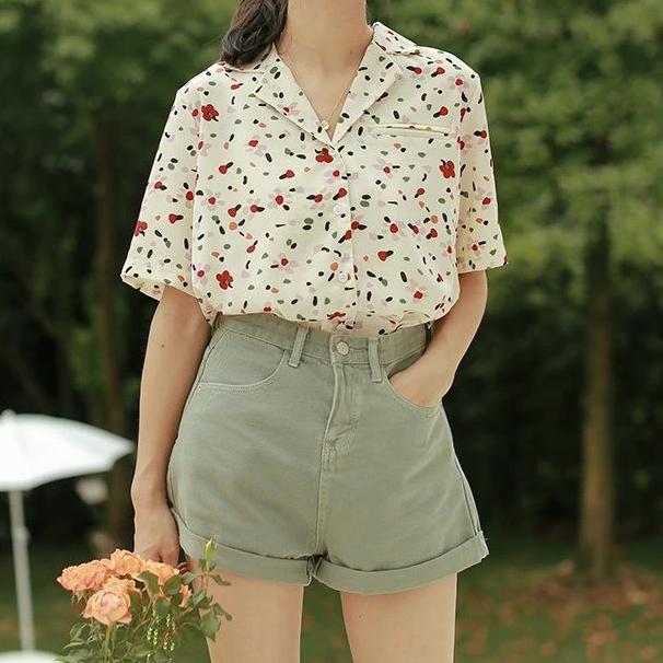 chemise manches courtes pour femme à motifs floraux portée avec un short, idéale pour une tenue estivale décontractée